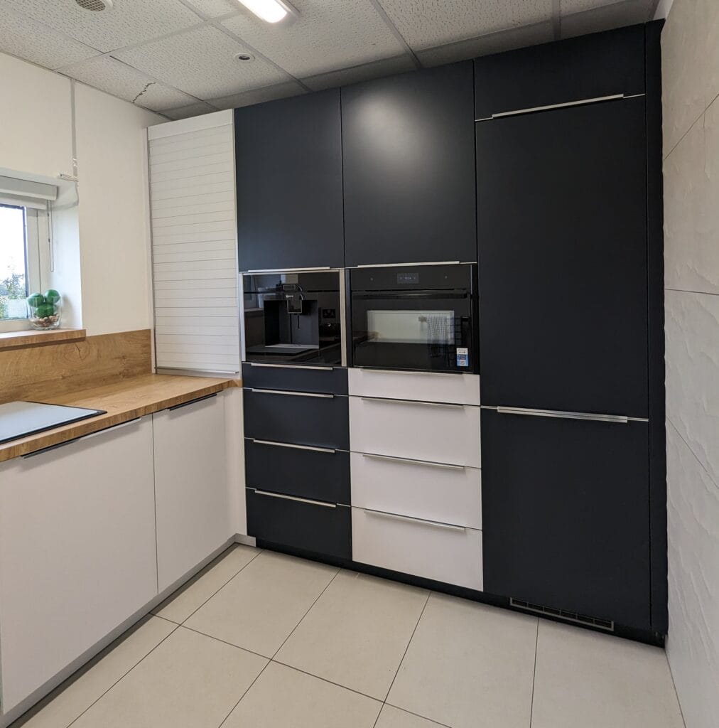 A picture of our frosted glass kitchen with velvet blue and white frosted glass doors, natural vintage oak laminate worktop and tambour roller door unit.