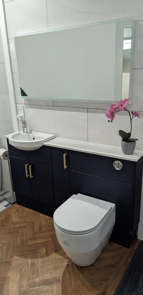 Blue corridor bathroom with basin unit, hidden cistern WC and deep blue cabinets, with solid stone worktop
