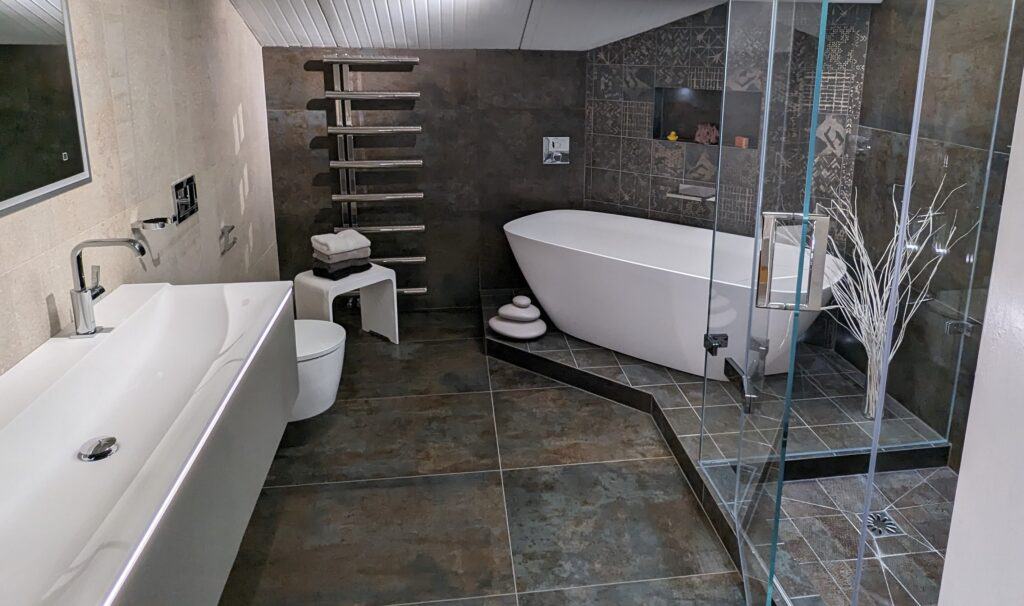 Bathroom complete with freestanding bath, continuous his and hers sinks, and steam room shower